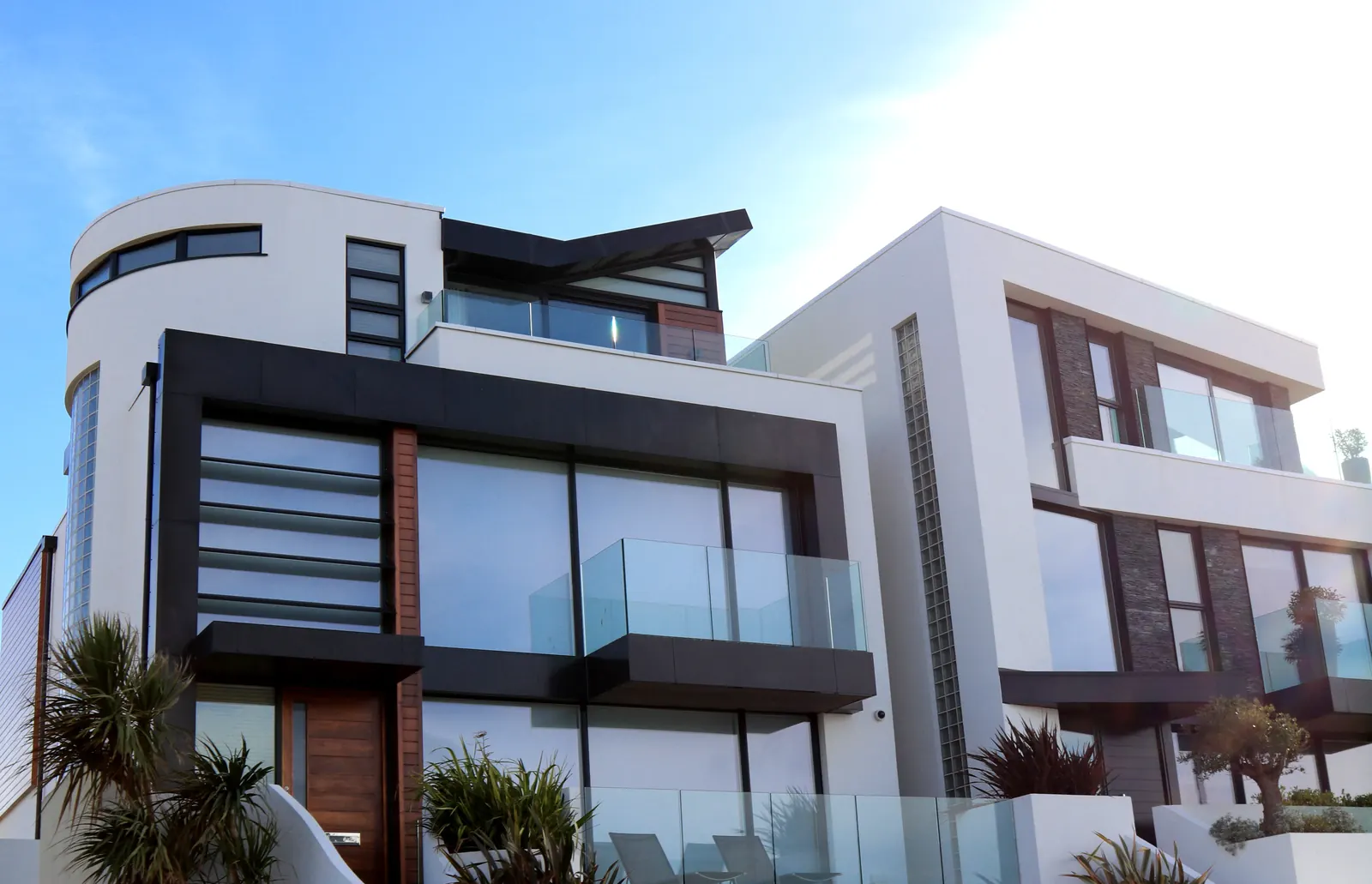 Modern apartments with glass balconies and palm trees